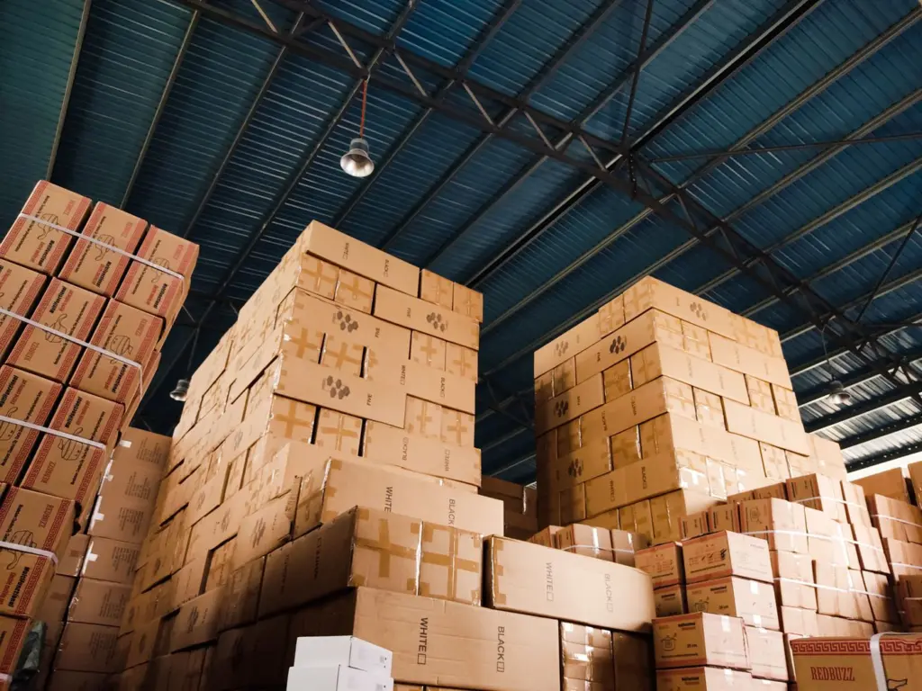Vom Dropshipping zum Großhandel: Wann lohnt sich der Wechsel? 1 Gestapelte Warenkartons in einem Lager als Symbol für den Wechsel zu größeren Einkaufsmengen
